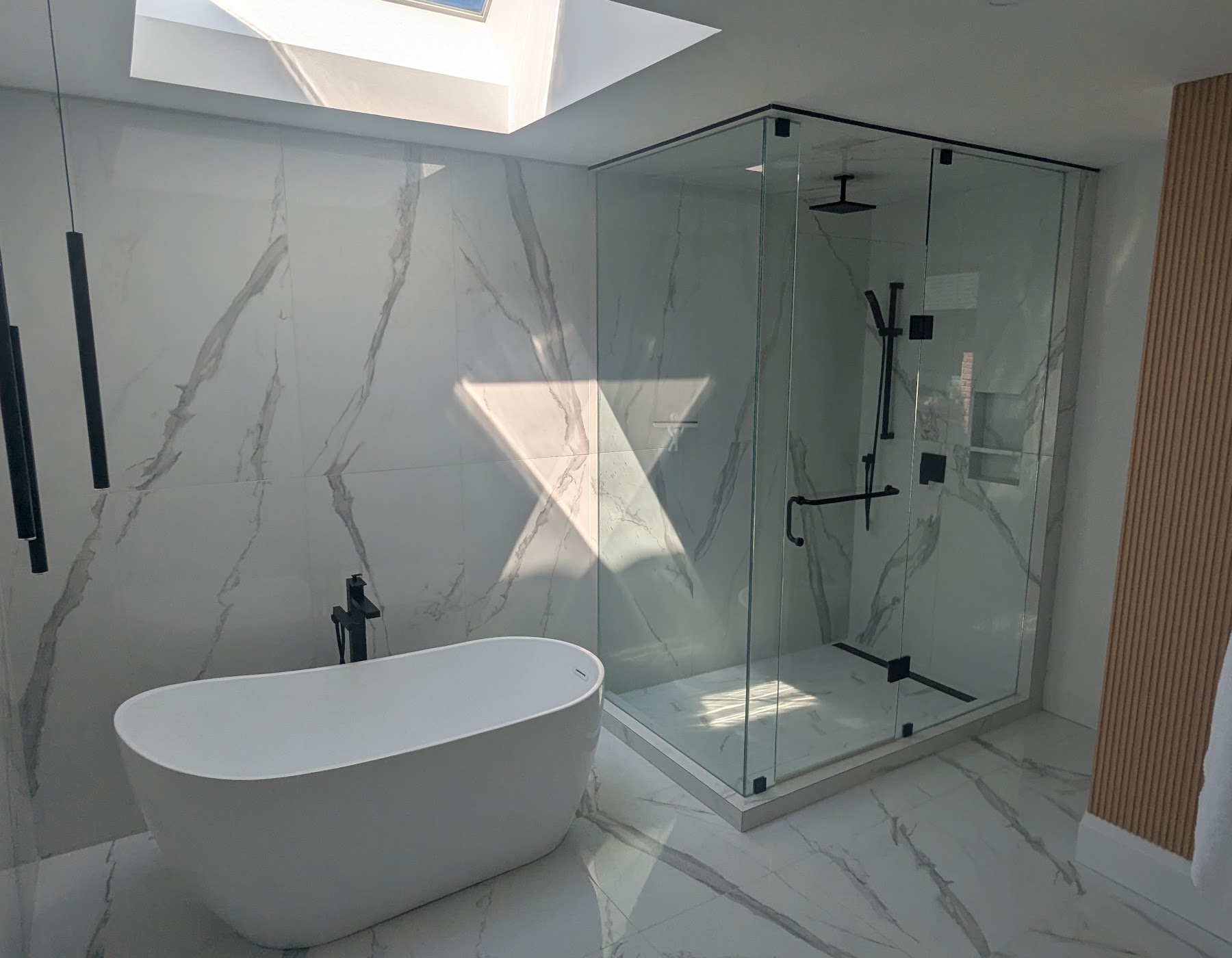Finished bathroom with freestanding tub and glass shower