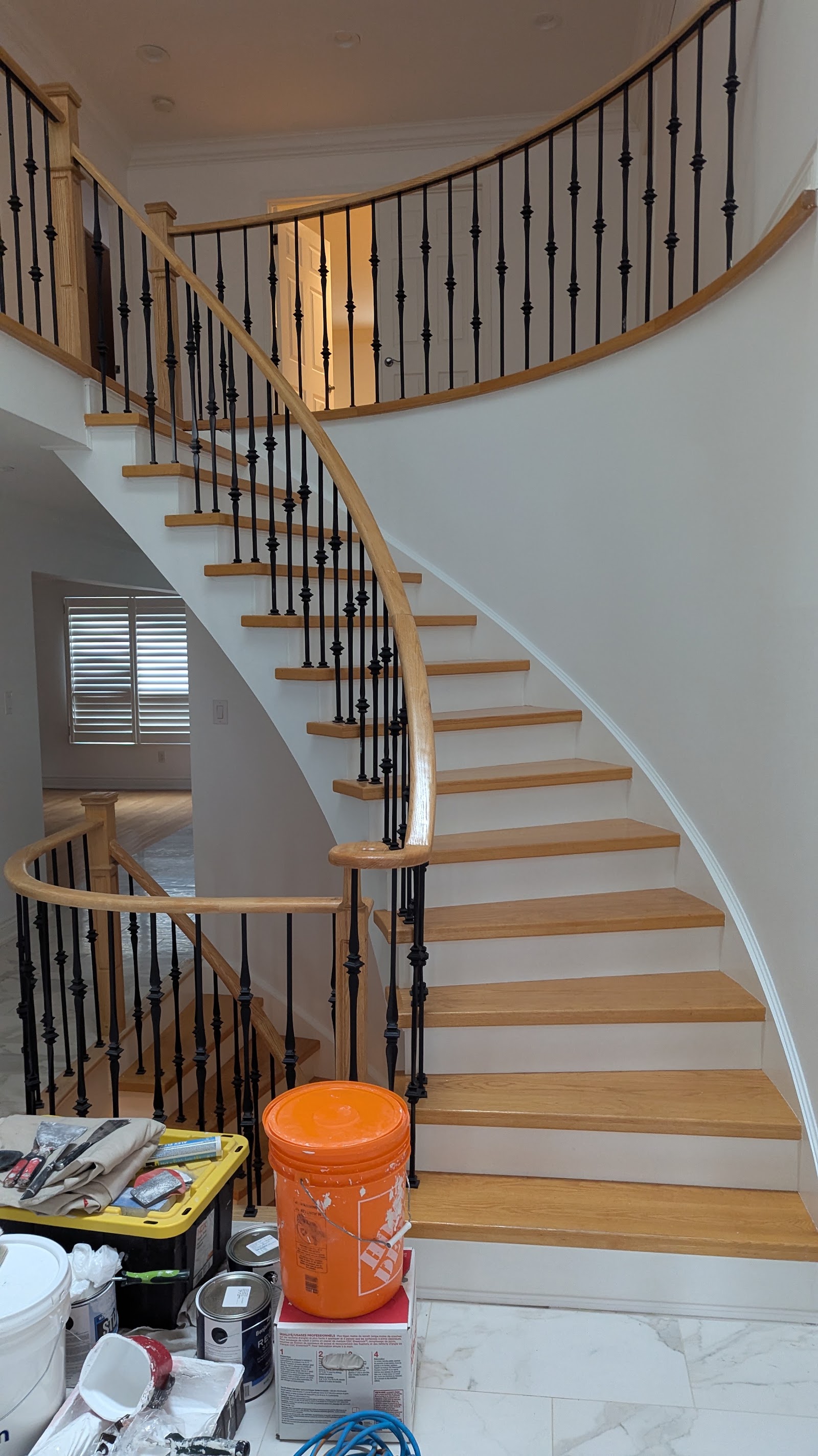 Finished staircase with wood rail and black spindles